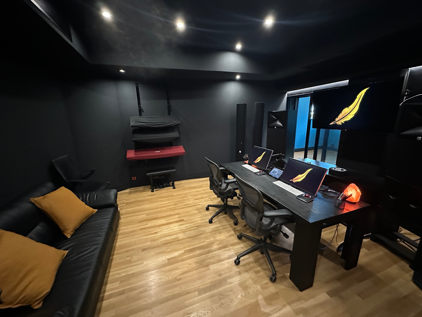 The control room at Lonely Feather Studios, with keyboards, monitors, and a production desk